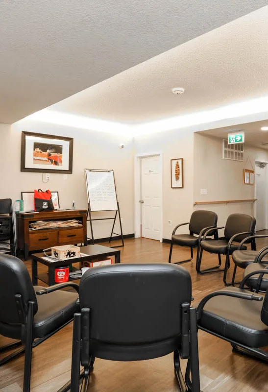 chairs placed in a circle around a central coffee table. all within the central room of the Inii Healing House (IHH)